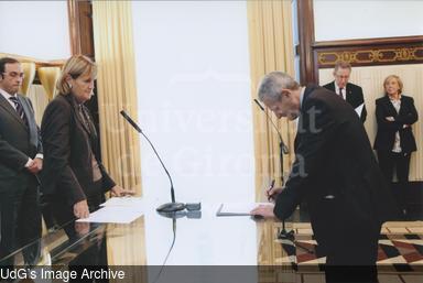 Acte de signatura del secretari general de la Universitat de Girona, Carles Abellà Ametller, en representació de la rectora Anna Maria Geli, amb la presidenta del Parlament de Catalunya. [Photograph]